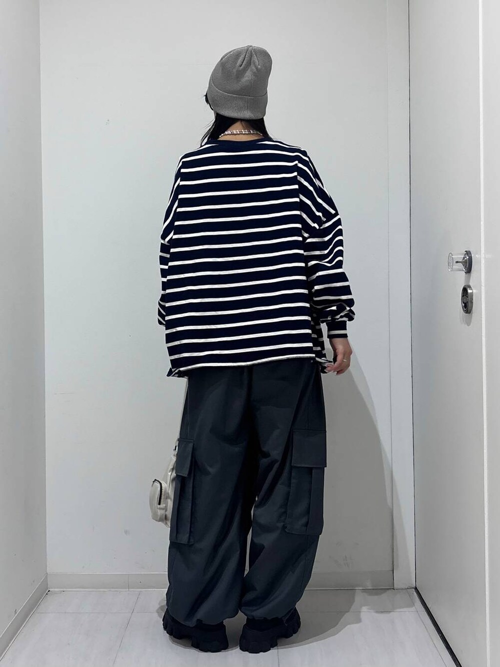 ブルー系のTシャツ/カットソー、グレー系のカーゴパンツ、グレー系のニットキャップ/ビーニーを着用したレディースの冬コーディネートの4枚目の写真