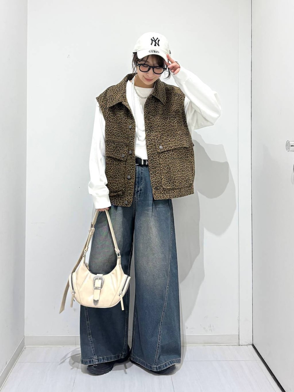 ブルー系のデニムパンツ、ホワイト系のスウェット、ブラック系のスニーカーを着用したレディースの春コーディネートの7枚目の写真