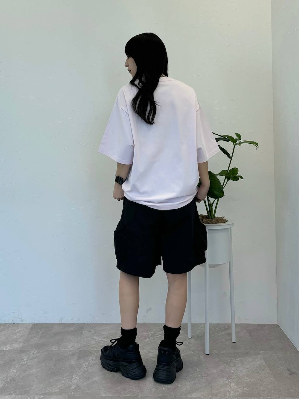 ブラック系のスニーカー、ブラック系のカーゴパンツ、ホワイト系のTシャツ/カットソーを着用したレディースの春コーディネートの4枚目の写真