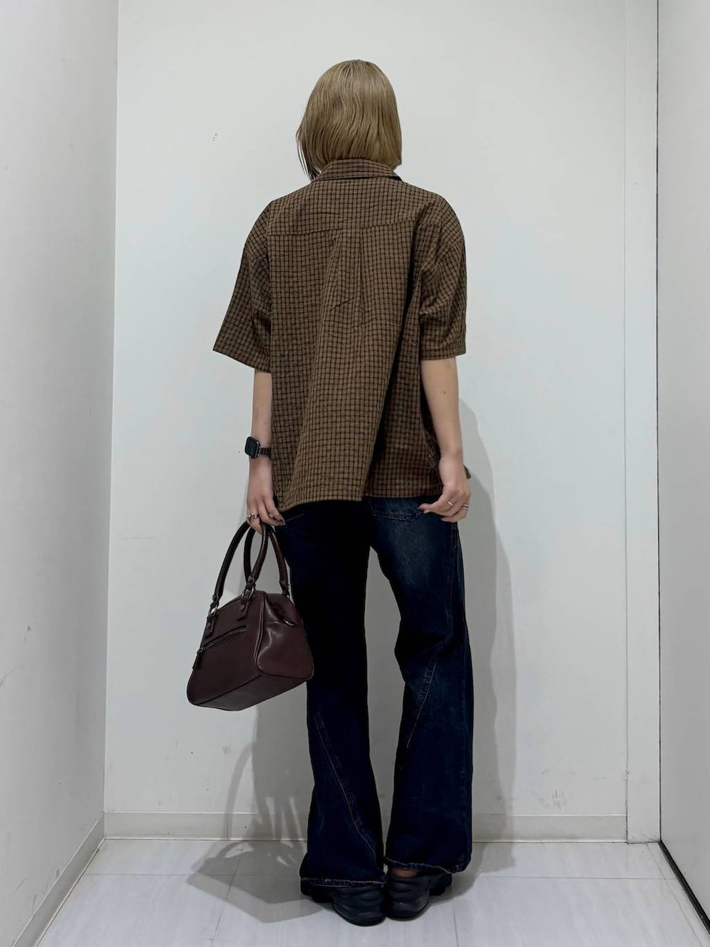 ブラウン系のショルダーバッグ、ブルー系のデニムパンツ、ブラウン系のシャツ/ブラウスを着用したレディースの夏コーディネートの4枚目の写真