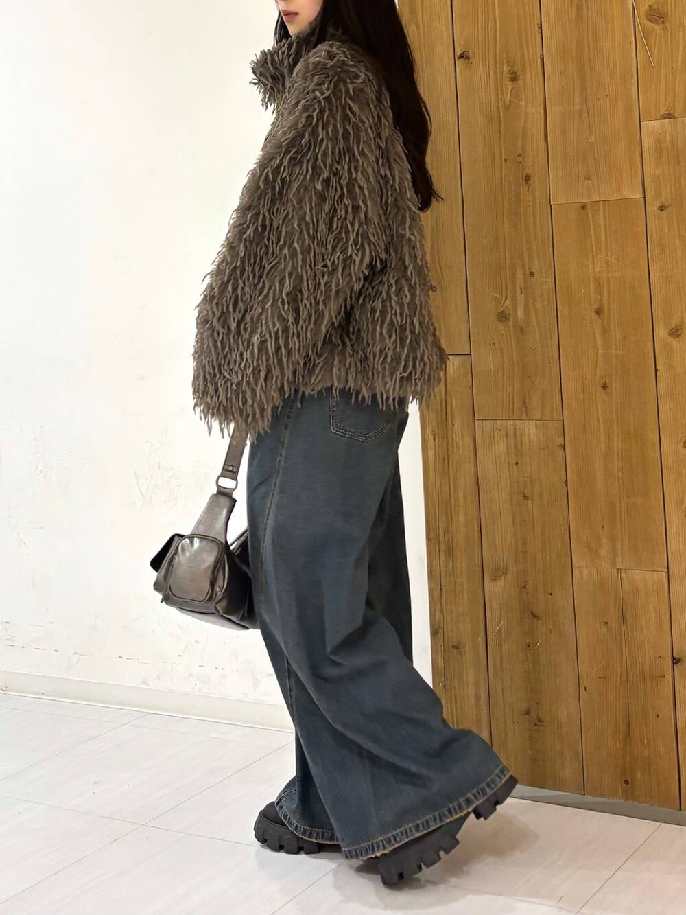 ブルー系のデニムパンツ、その他のショルダーバッグ、ブラウン系のブルゾンを着用したレディースの冬コーディネートの3枚目の写真