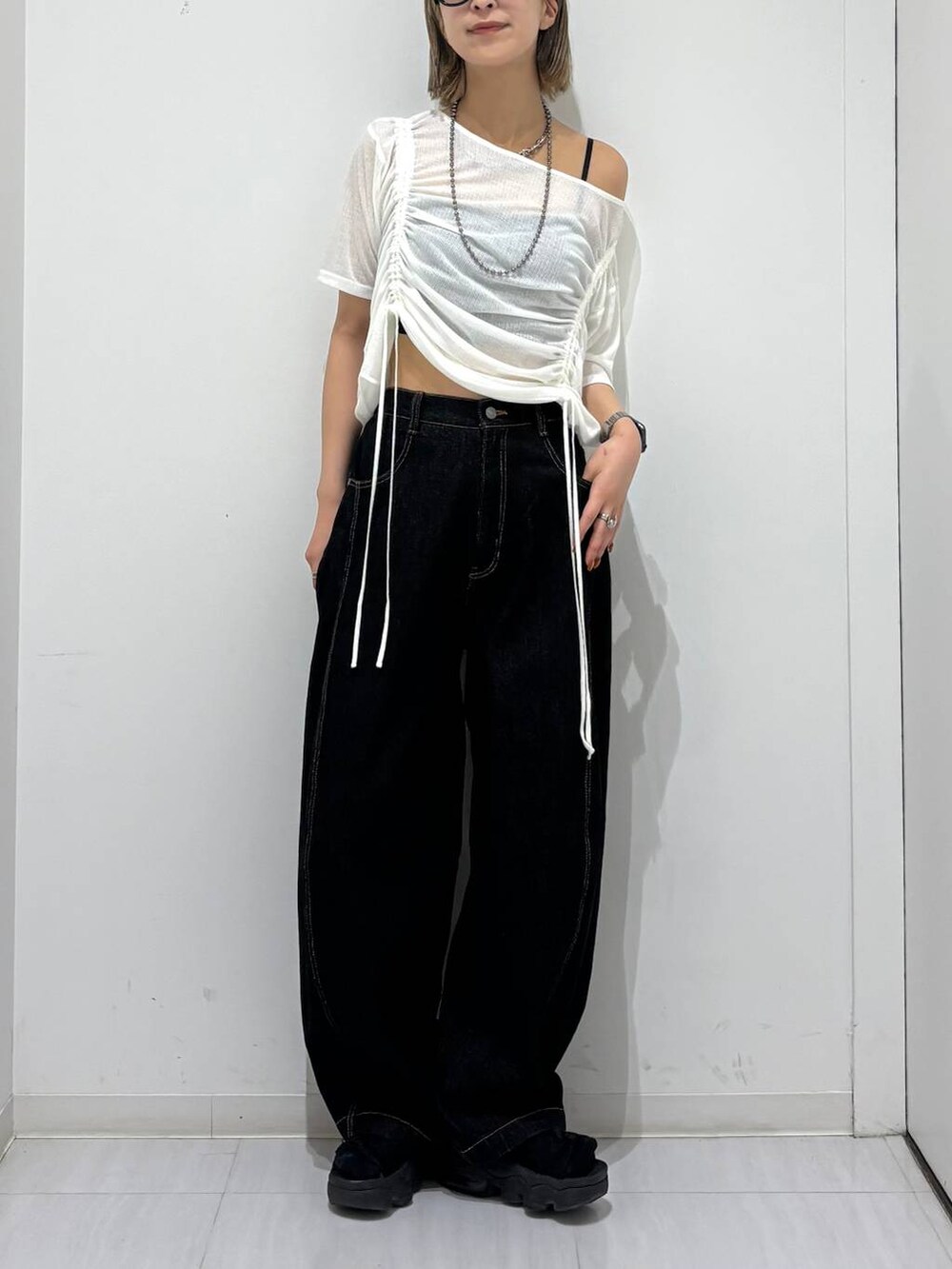 ブラック系のデニムパンツ、ホワイト系のTシャツ/カットソー、ブラック系のネックレスを着用したレディースの夏コーディネートの3枚目の写真