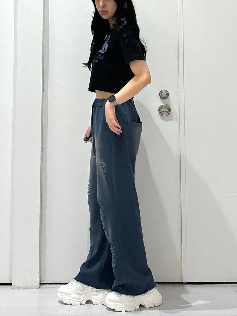 ホワイト系のスニーカー、ブルー系のスウェットパンツを着用したレディースの夏コーディネートの4枚目の写真