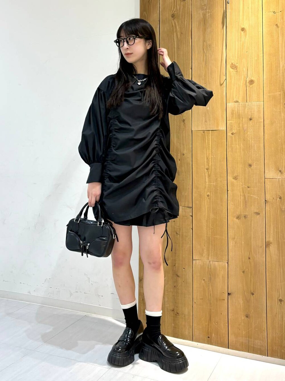 ブラック系のワンピース、ブラック系のローファー、ブラック系のボストンバッグを着用したレディースの春コーディネートの5枚目の写真