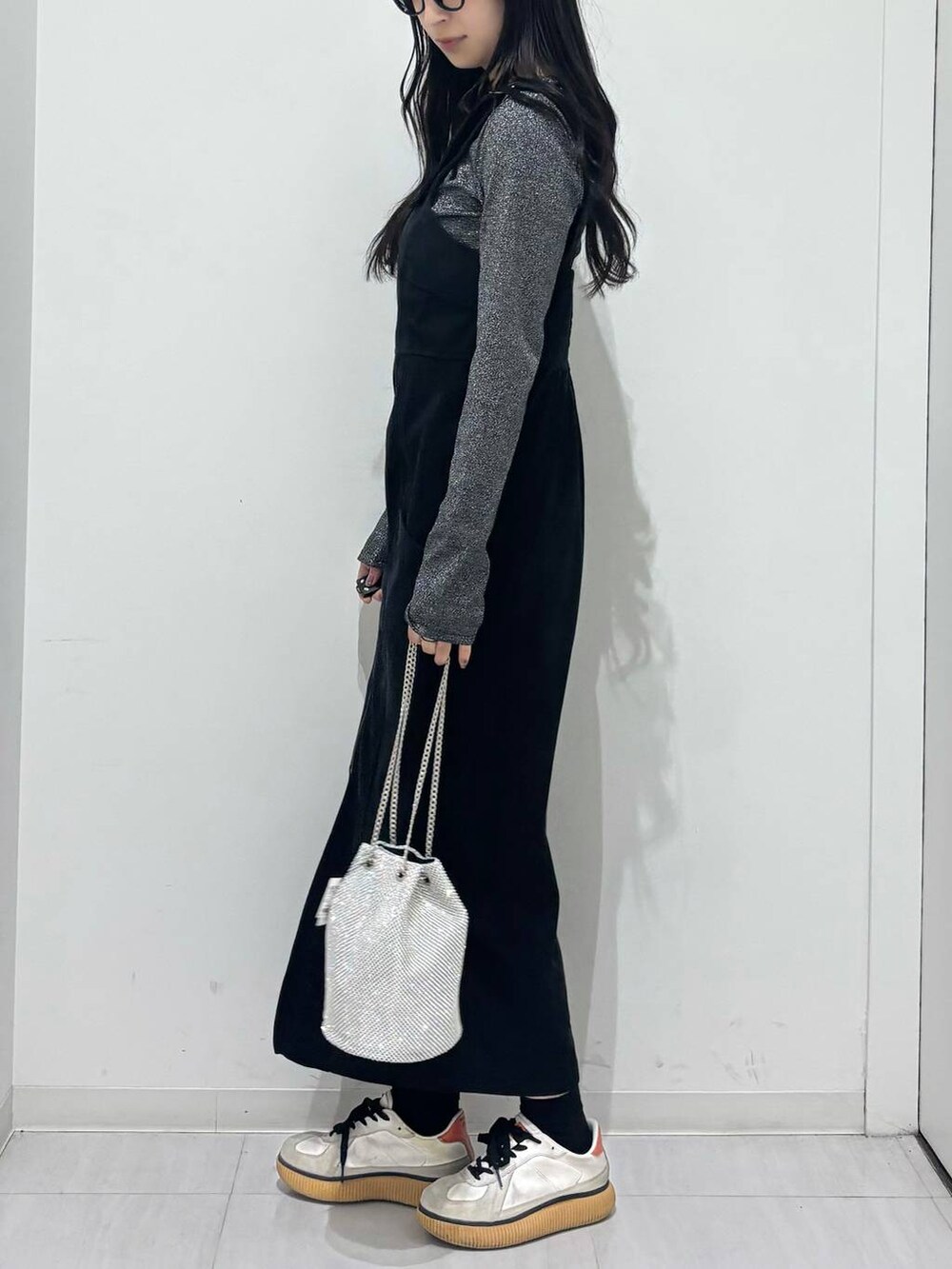シルバー系のショルダーバッグ、シルバー系のTシャツ/カットソー、ブラック系のワンピースを着用したレディースの秋コーディネートの3枚目の写真