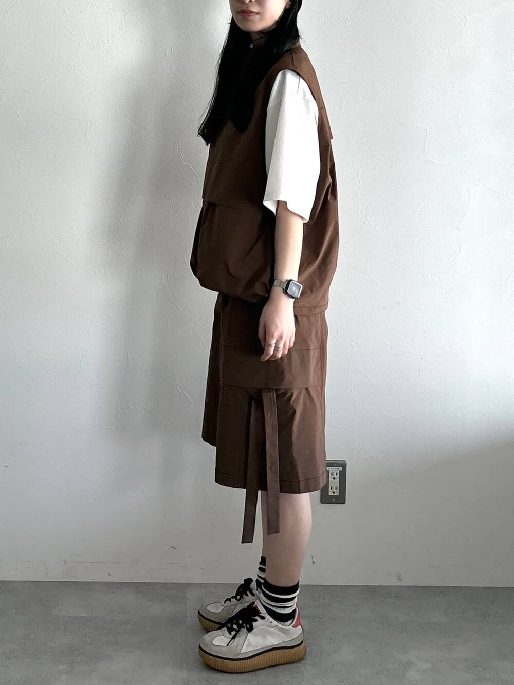 ホワイト系のTシャツ/カットソー、ブラウン系のベスト、ブラウン系のカーゴパンツを着用したレディースの夏コーディネートの3枚目の写真