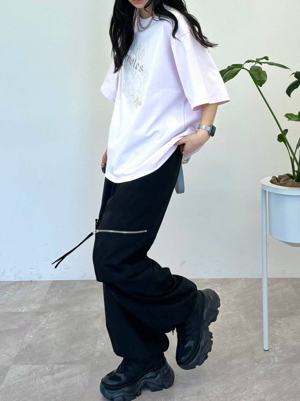 シルバー系のショルダーバッグ、ブラック系のスニーカー、ピンク系のTシャツ/カットソーを着用したレディースの春コーディネートの2枚目の写真