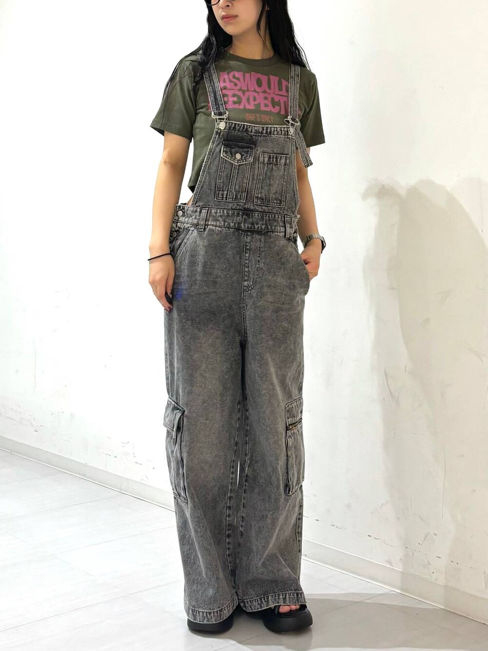 ブラック系のサンダル、ブラック系のサロペット/オーバーオール、グリーン系のTシャツ/カットソーを着用したレディースの夏コーディネートの5枚目の写真