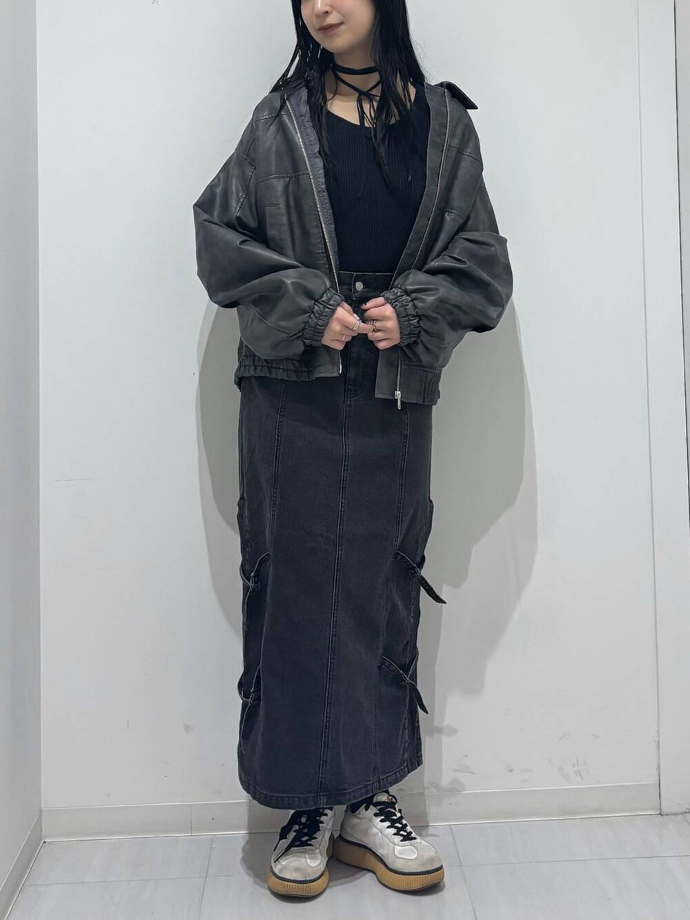 ブラック系のブルゾン、ブラック系のデニムスカート、ブラック系のニット/セーターを着用したレディースの秋コーディネートの4枚目の写真