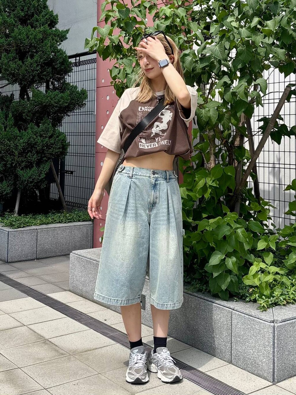 ブルー系のその他パンツ、グレー系のショルダーバッグ、ブラウン系のTシャツ/カットソーを着用したレディースの夏コーディネートの2枚目の写真