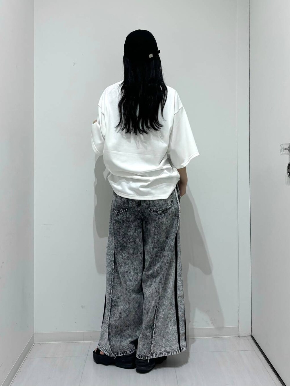 ホワイト系のTシャツ/カットソー、グレー系のデニムパンツ、ブラック系のキャップを着用したレディースの夏コーディネートの4枚目の写真