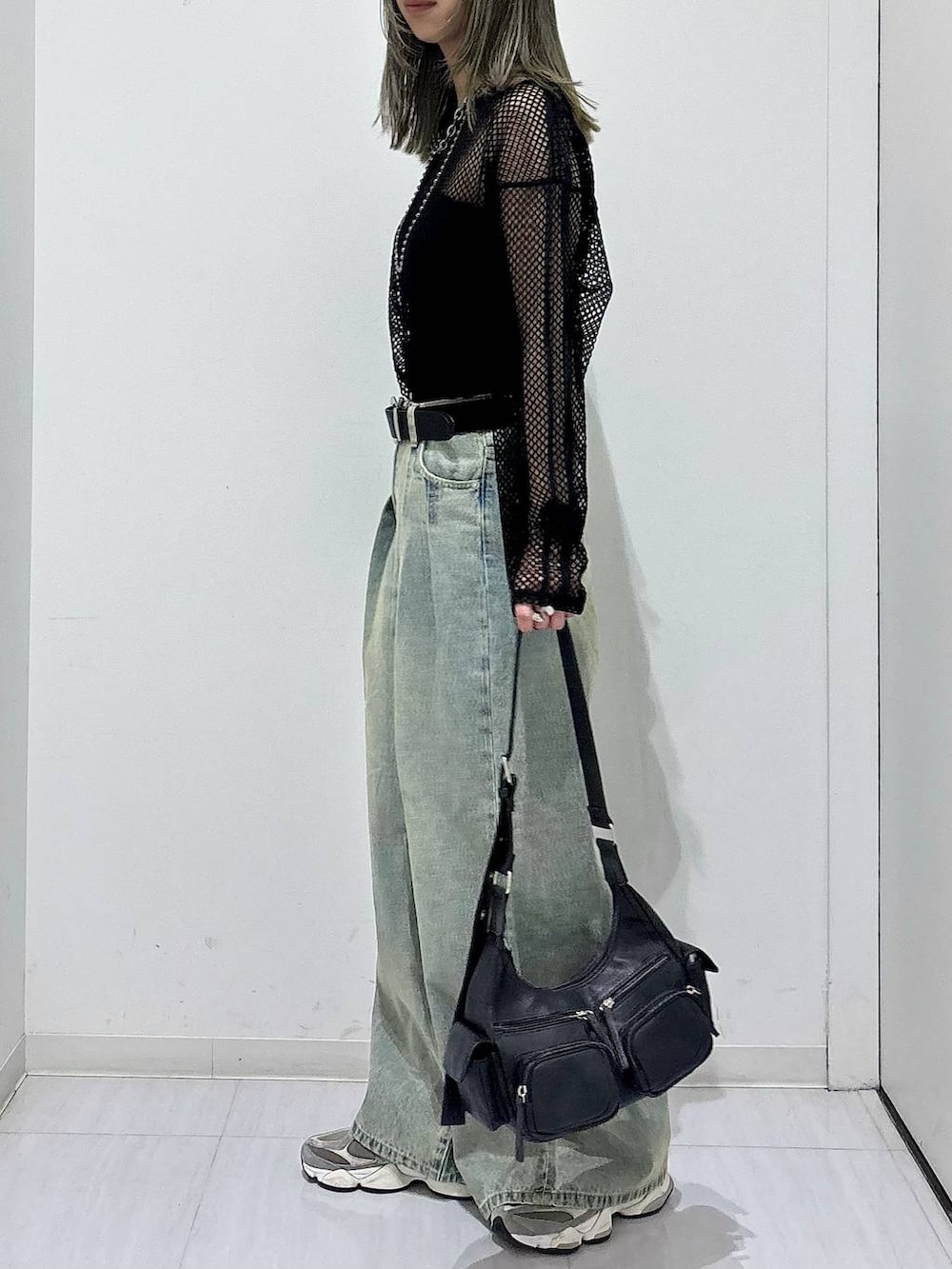 ブルー系のデニムパンツ、ブラック系のTシャツ/カットソー、ブラック系のショルダーバッグを着用したレディースの春コーディネートの3枚目の写真