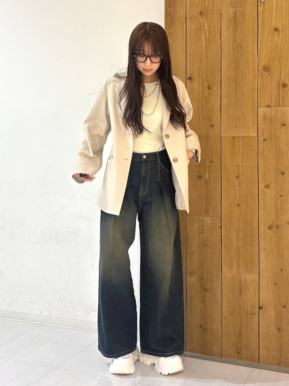 ホワイト系のスニーカー、ブルー系のデニムパンツ、ホワイト系のTシャツ/カットソーを着用したレディースの冬コーディネートの2枚目の写真