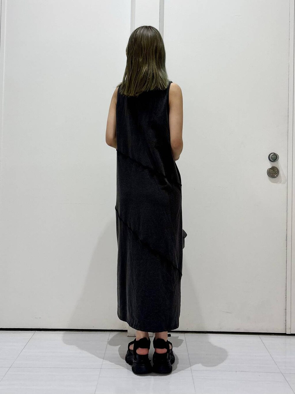 ブラック系のサンダル、ブラック系のワンピース、ブラック系のショルダーバッグを着用したレディースの春コーディネートの6枚目の写真