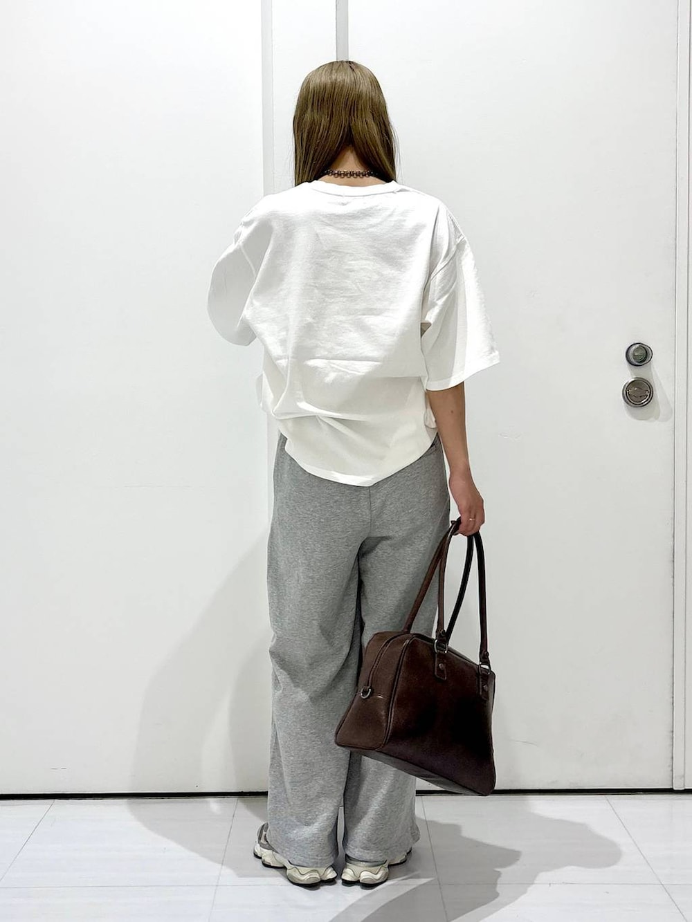 ブラウン系のボストンバッグ、ホワイト系のTシャツ/カットソー、グレー系のスウェットパンツを着用したレディースの春コーディネートの4枚目の写真