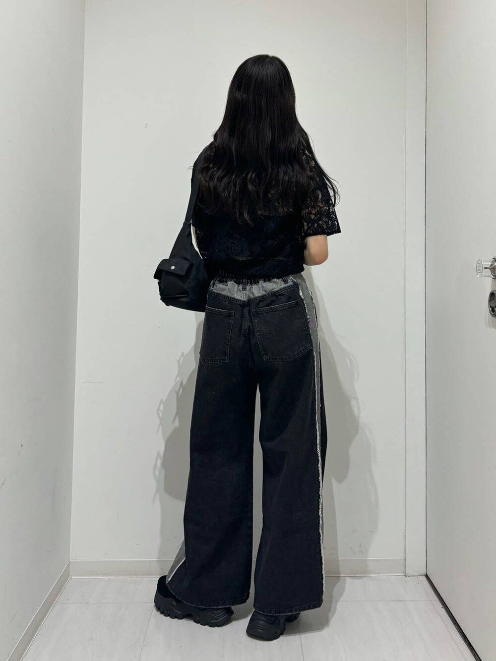 ブラック系のショルダーバッグ、ブラック系のシャツ/ブラウス、ブラック系のデニムパンツを着用したレディースの春コーディネートの3枚目の写真