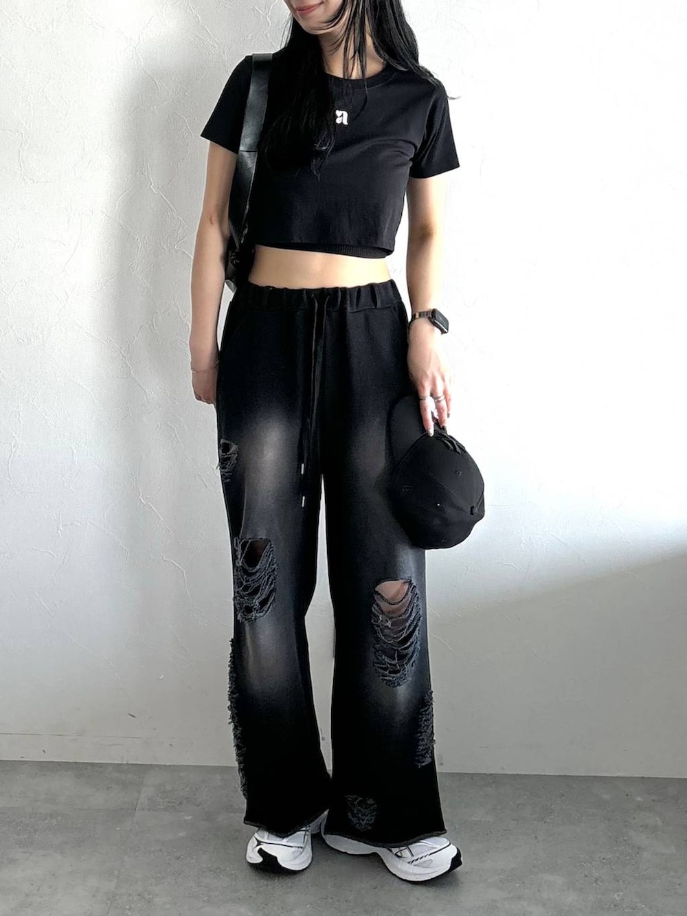 ブラック系のスウェットパンツ、ブラック系のTシャツ/カットソー、ブラック系のショルダーバッグを着用したレディースの春コーディネートの2枚目の写真