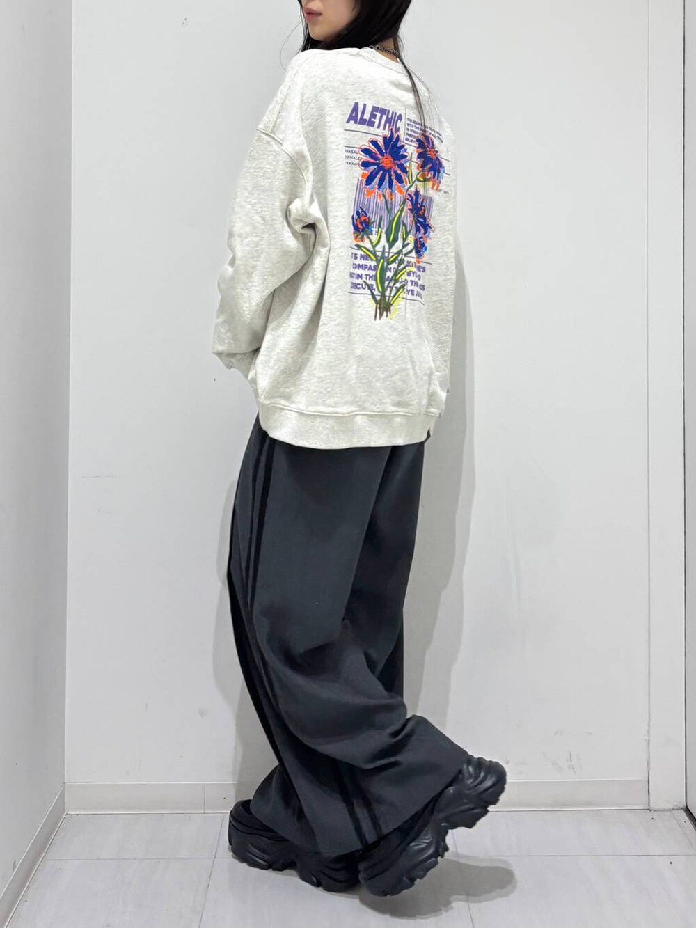 ブラック系のスニーカー、ベージュ系のスウェット、グレー系のスラックスを着用したレディースの冬コーディネートの2枚目の写真