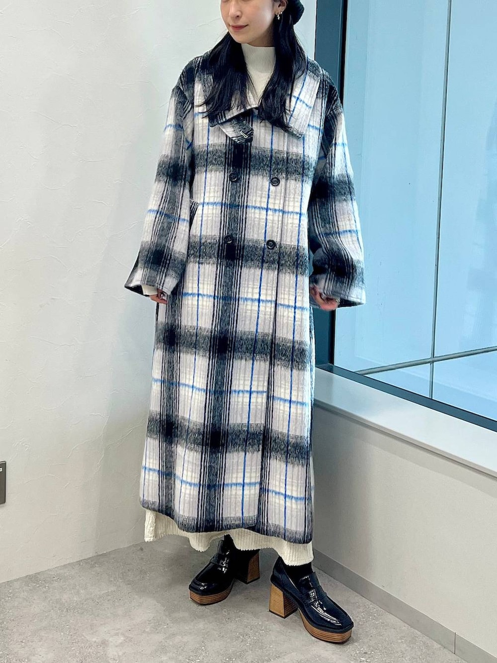 ホワイト系のステンカラーコート、ホワイト系のワンピース、ホワイト系のニット/セーターを着用したレディースの秋コーディネートの6枚目の写真