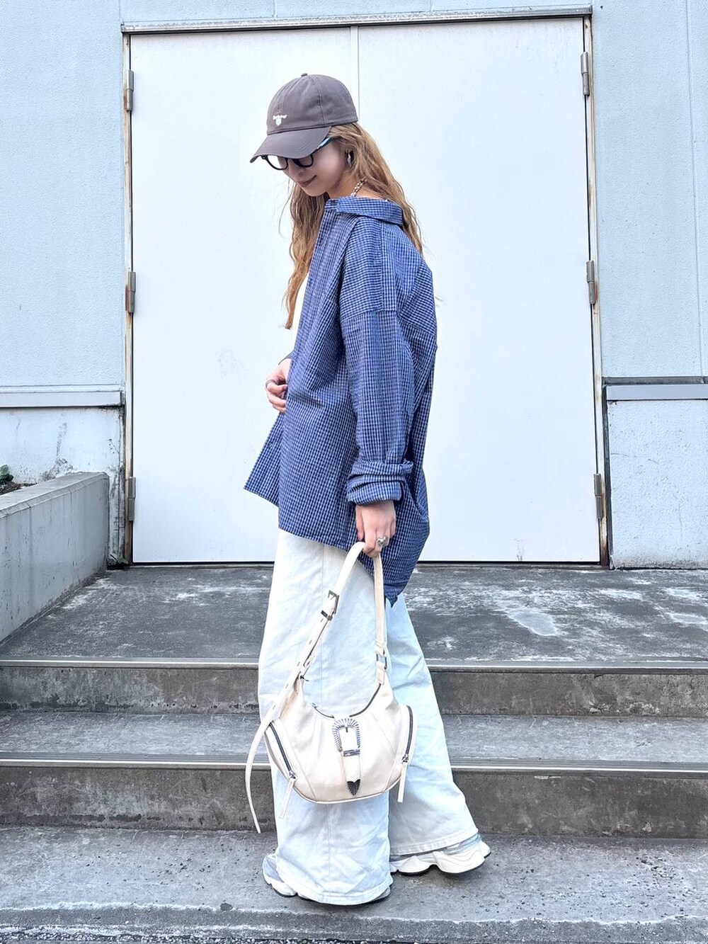 グレー系のデニムパンツ、ホワイト系のショルダーバッグ、ブルー系のシャツ/ブラウスを着用したレディースの春コーディネートの4枚目の写真
