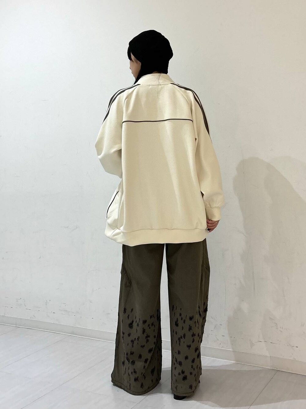 ブラック系のパンプス、ブラック系のデニムパンツ、ホワイト系のジャージを着用したレディースの夏コーディネートの3枚目の写真