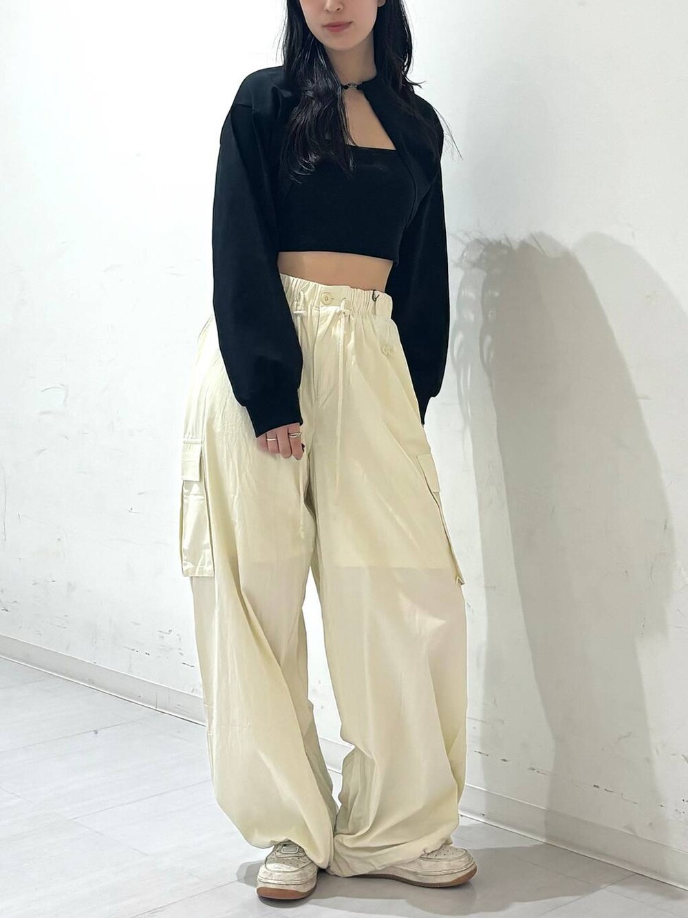 ホワイト系のカーゴパンツ、ブラック系のキャミソール、ブラック系のカーディガン/ボレロを着用したレディースの春コーディネートの2枚目の写真