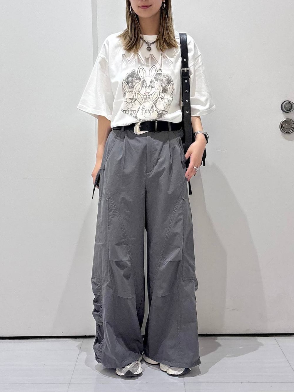 ブラック系のショルダーバッグ、グレー系のカーゴパンツ、ホワイト系のTシャツ/カットソーを着用したレディースの春コーディネートの6枚目の写真