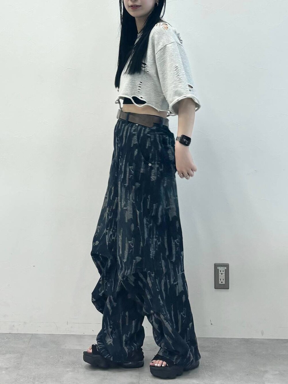 ブルー系のデニムパンツ、グレー系のTシャツ/カットソー、ブラウン系のベルトを着用したレディースの夏コーディネートの2枚目の写真