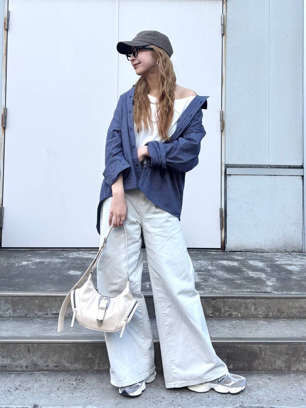 グレー系のデニムパンツ、ホワイト系のショルダーバッグ、ブルー系のシャツ/ブラウスを着用したレディースの春コーディネートの2枚目の写真