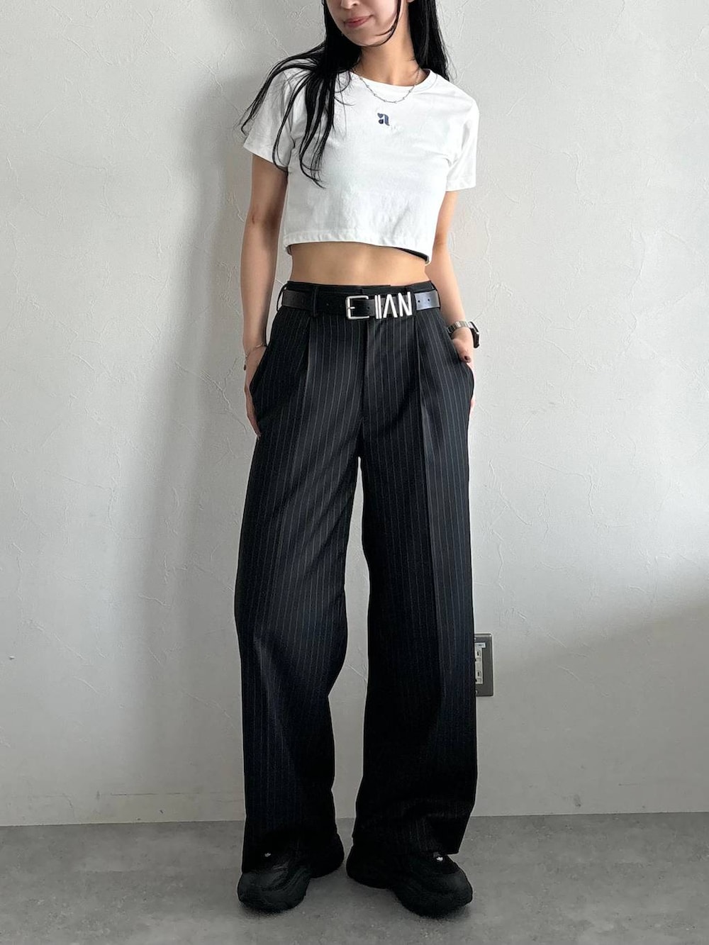 ホワイト系のTシャツ/カットソー、ブラック系のスラックス、ブラック系のベルトを着用したレディースの春コーディネートの5枚目の写真