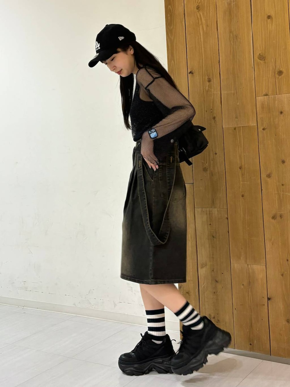 ブラック系のスニーカー、ブラック系のTシャツ/カットソー、ブラック系のデニムパンツを着用したレディースの春コーディネートの3枚目の写真