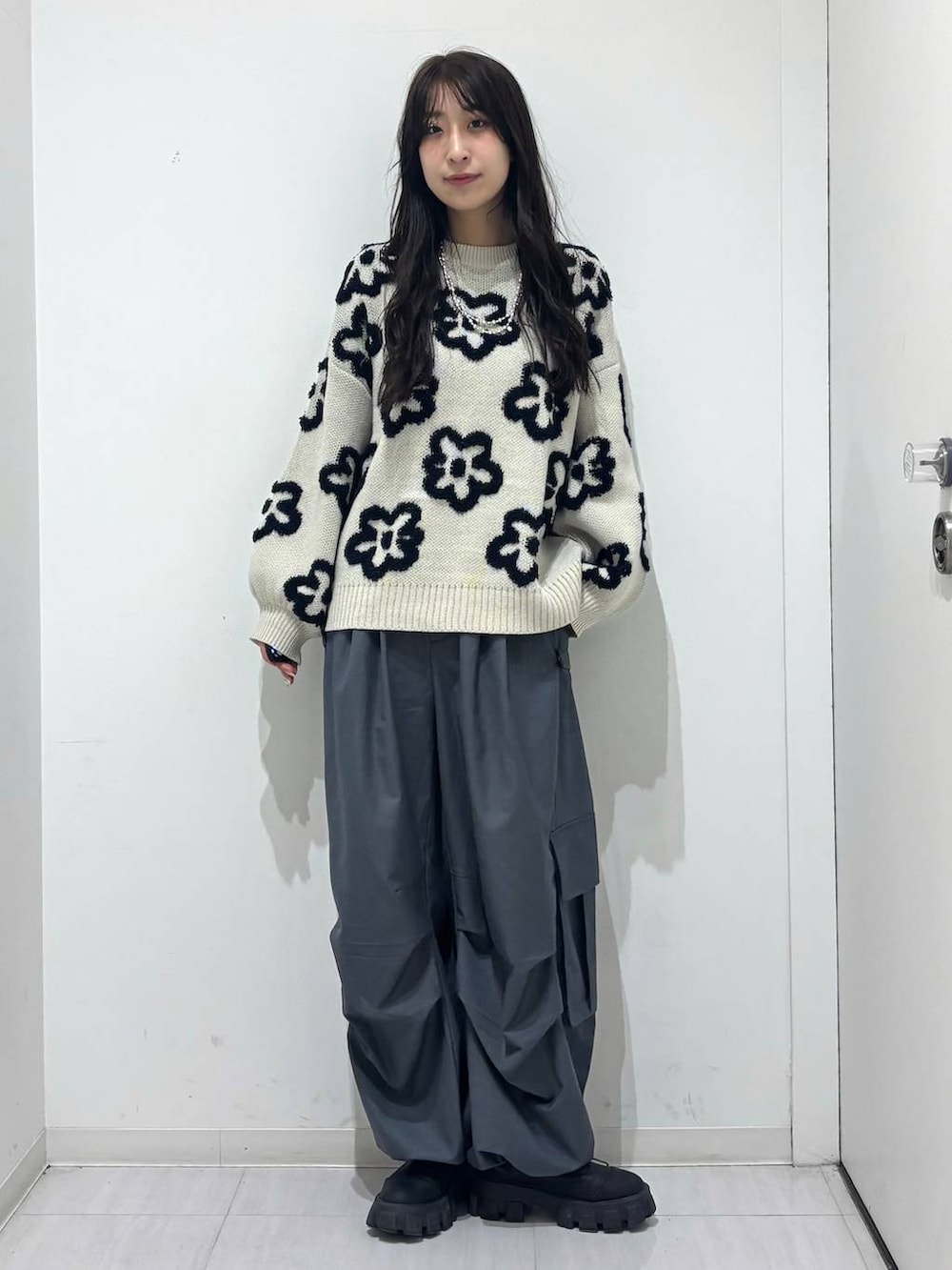 グレー系のカーゴパンツ、ベージュ系のニット/セーターを着用したレディースの冬コーディネートの6枚目の写真