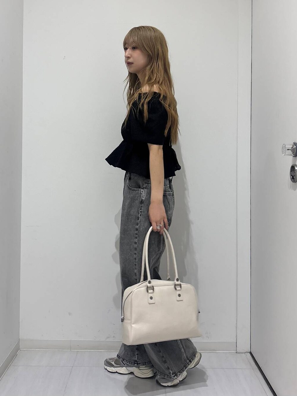 ホワイト系のボストンバッグ、ブラック系のデニムパンツ、ブラック系のシャツ/ブラウスを着用したレディースの春コーディネートの2枚目の写真