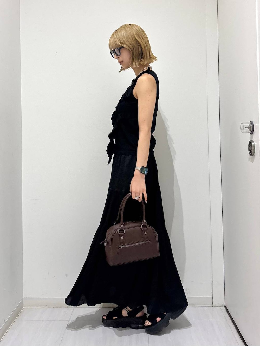 ブラウン系のショルダーバッグ、ブラック系のタンクトップ、ブラック系のスカートを着用したレディースの夏コーディネートの4枚目の写真
