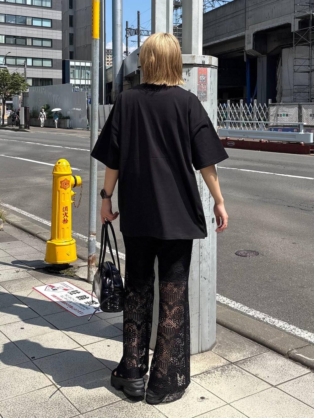 ブラック系のショルダーバッグ、ブラック系のTシャツ/カットソー、ホワイト系のネックレスを着用したレディースの夏コーディネートの5枚目の写真