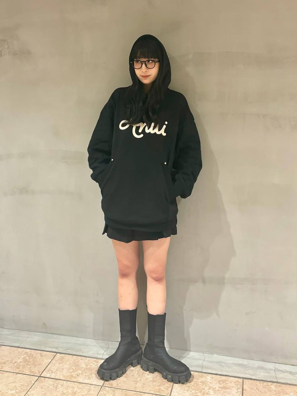 ブラック系のパーカー、ブラック系のブーツ、ブラック系のその他パンツを着用したレディースの冬コーディネートの5枚目の写真