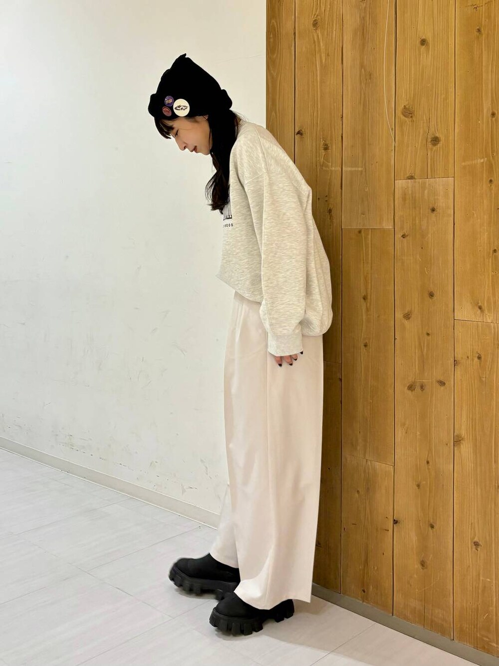 ブラック系のブーツ、ベージュ系のスラックス、ベージュ系のスウェットを着用したレディースの冬コーディネートの3枚目の写真