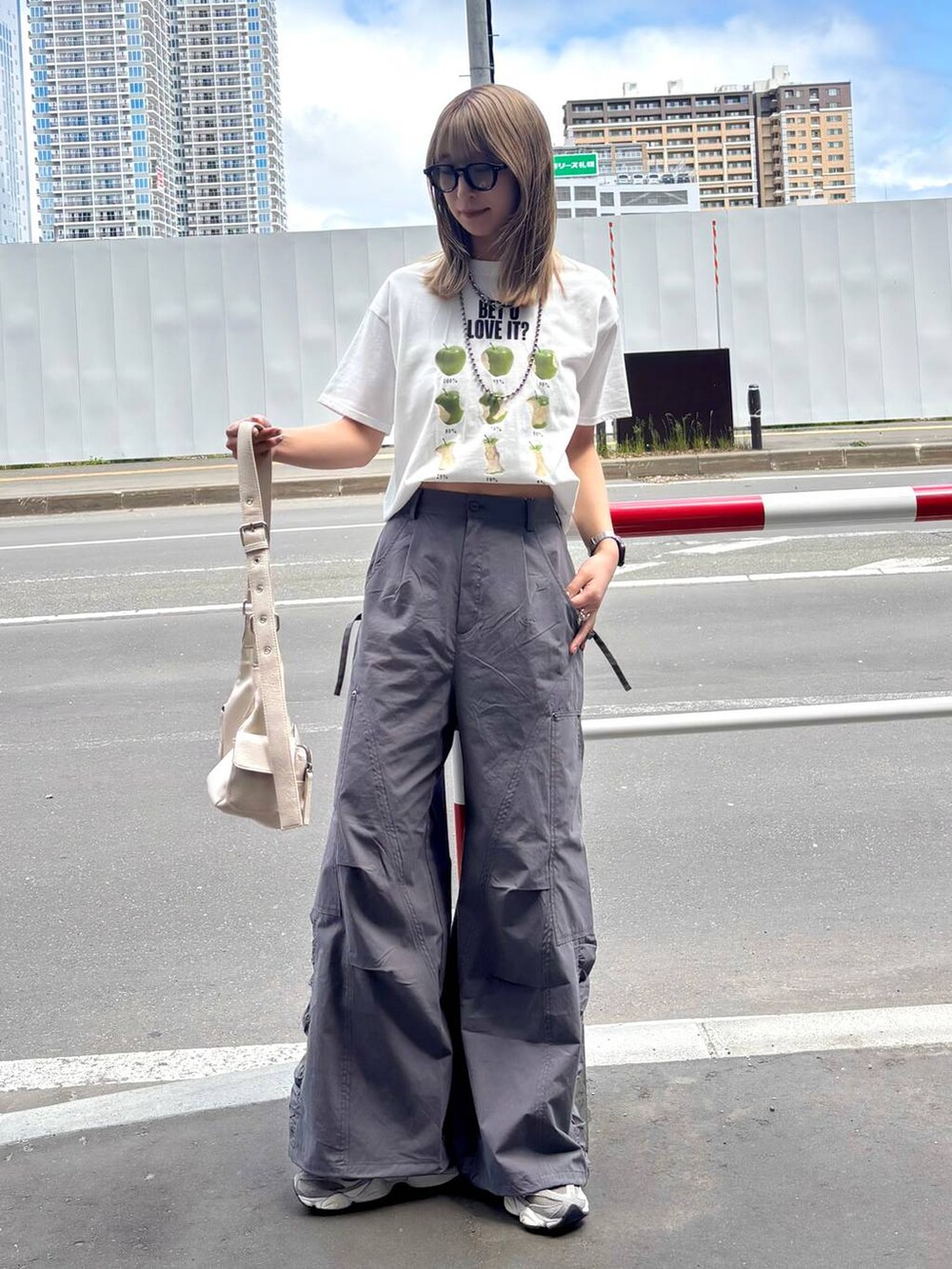 ホワイト系のショルダーバッグ、ホワイト系のTシャツ/カットソー、グレー系のカーゴパンツを着用したレディースの夏コーディネートの2枚目の写真