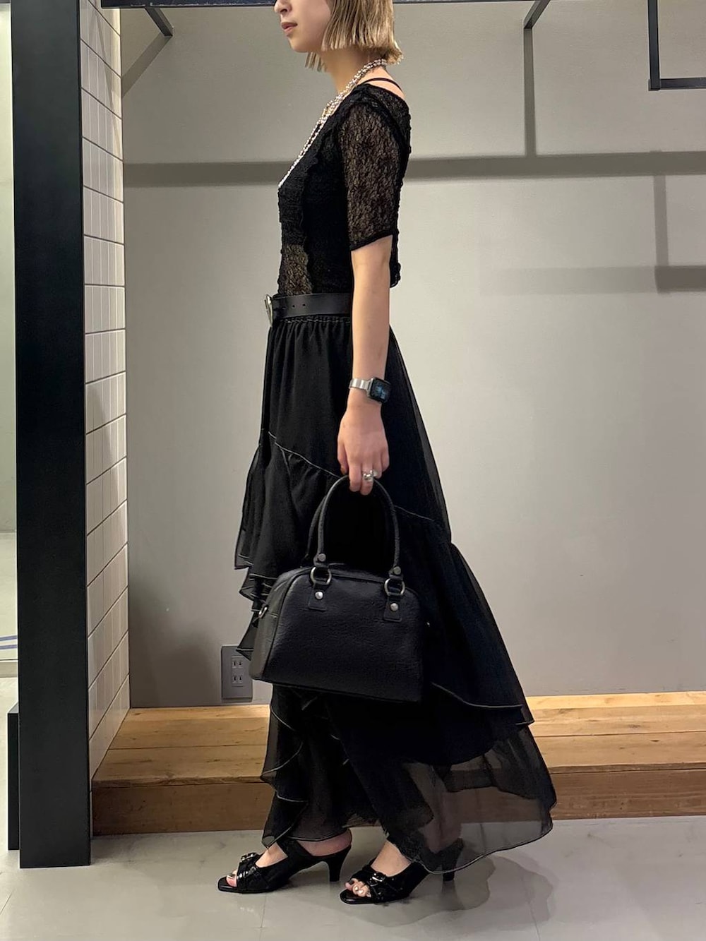 ブラック系のスカート、ブラック系のキャミソール、ブラック系のショルダーバッグを着用したレディースの夏コーディネートの3枚目の写真