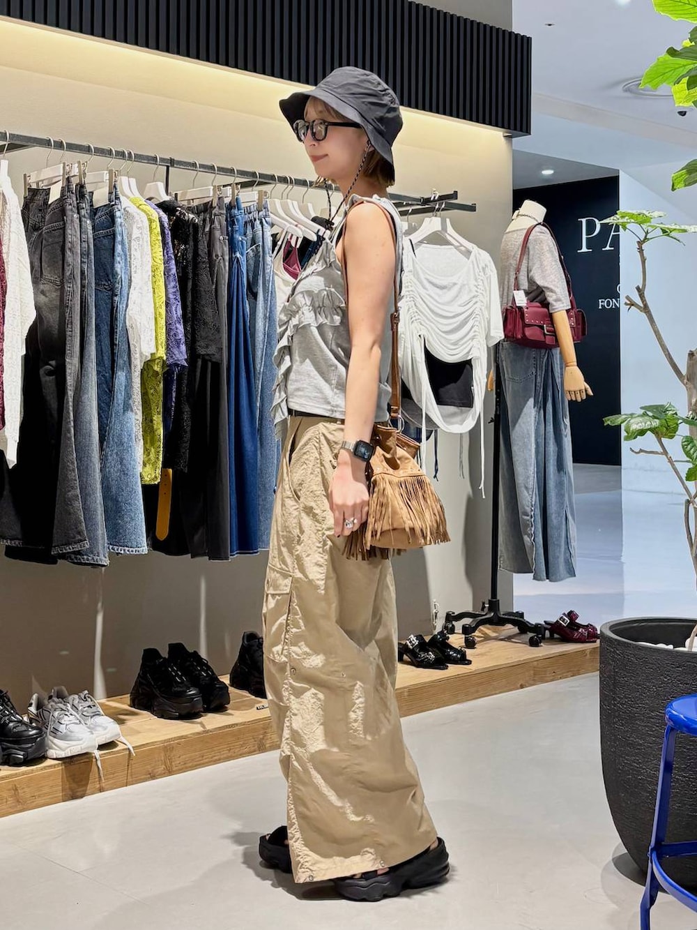 グレー系のタンクトップ、ベージュ系のカーゴパンツ、ブラック系のベルトを着用したレディースの夏コーディネートの5枚目の写真