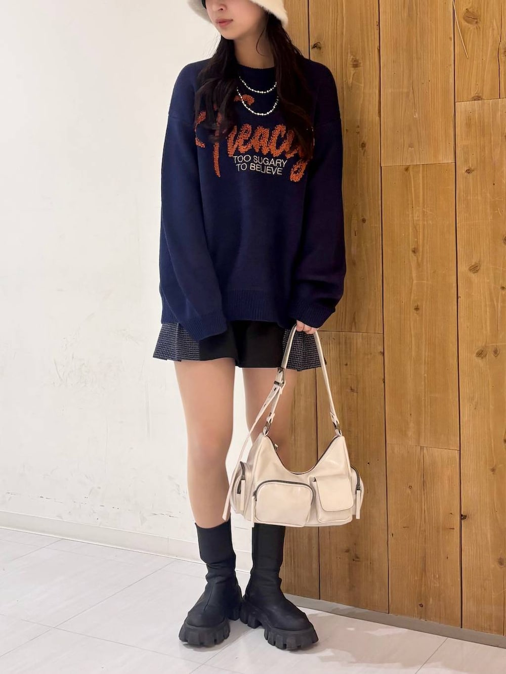 ブラック系のショルダーバッグ、ブルー系のニット/セーター、ブラック系のその他パンツを着用したレディースの冬コーディネートの2枚目の写真