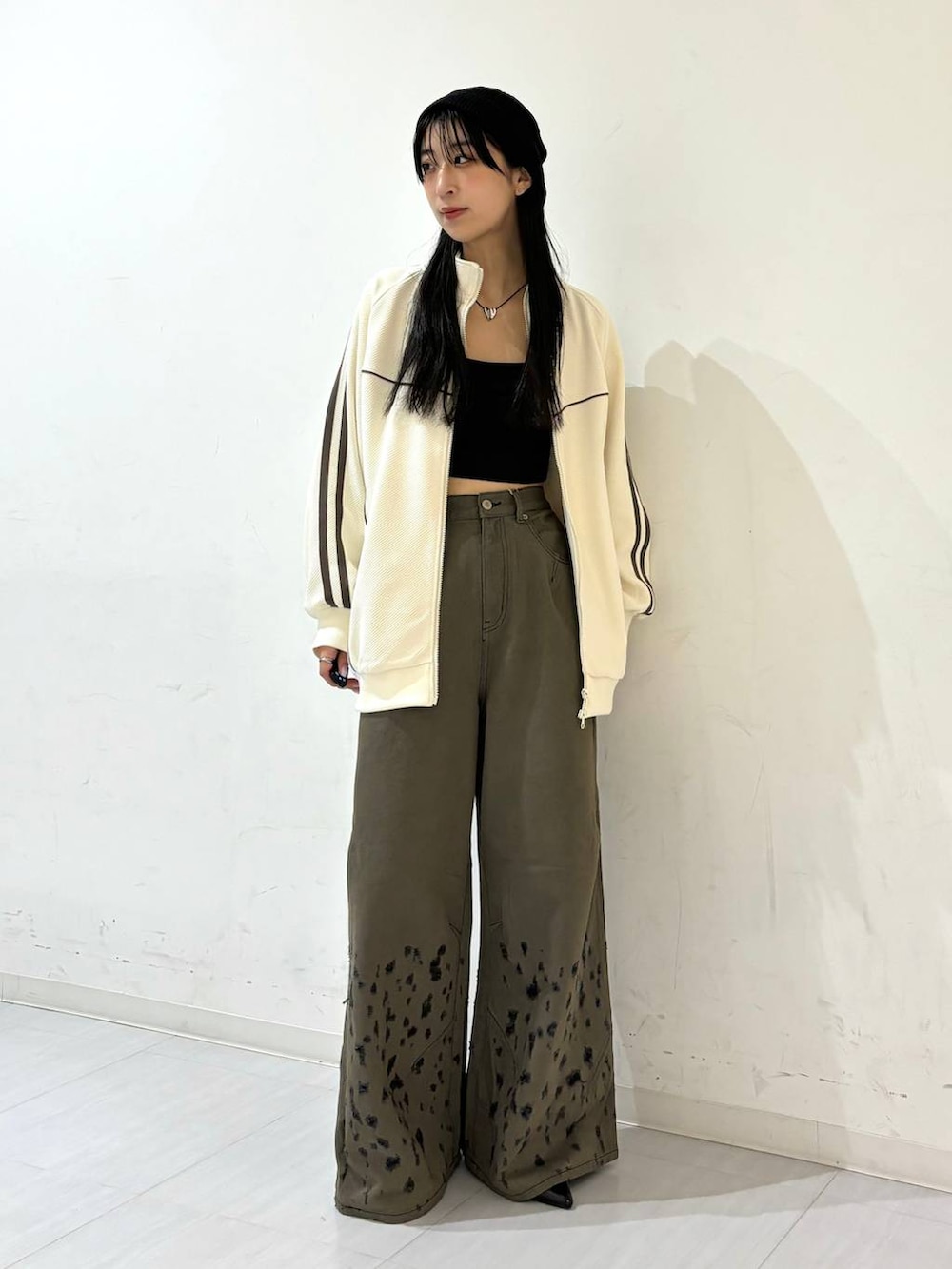 ブラック系のパンプス、ブラック系のデニムパンツ、ホワイト系のジャージを着用したレディースの夏コーディネートの4枚目の写真