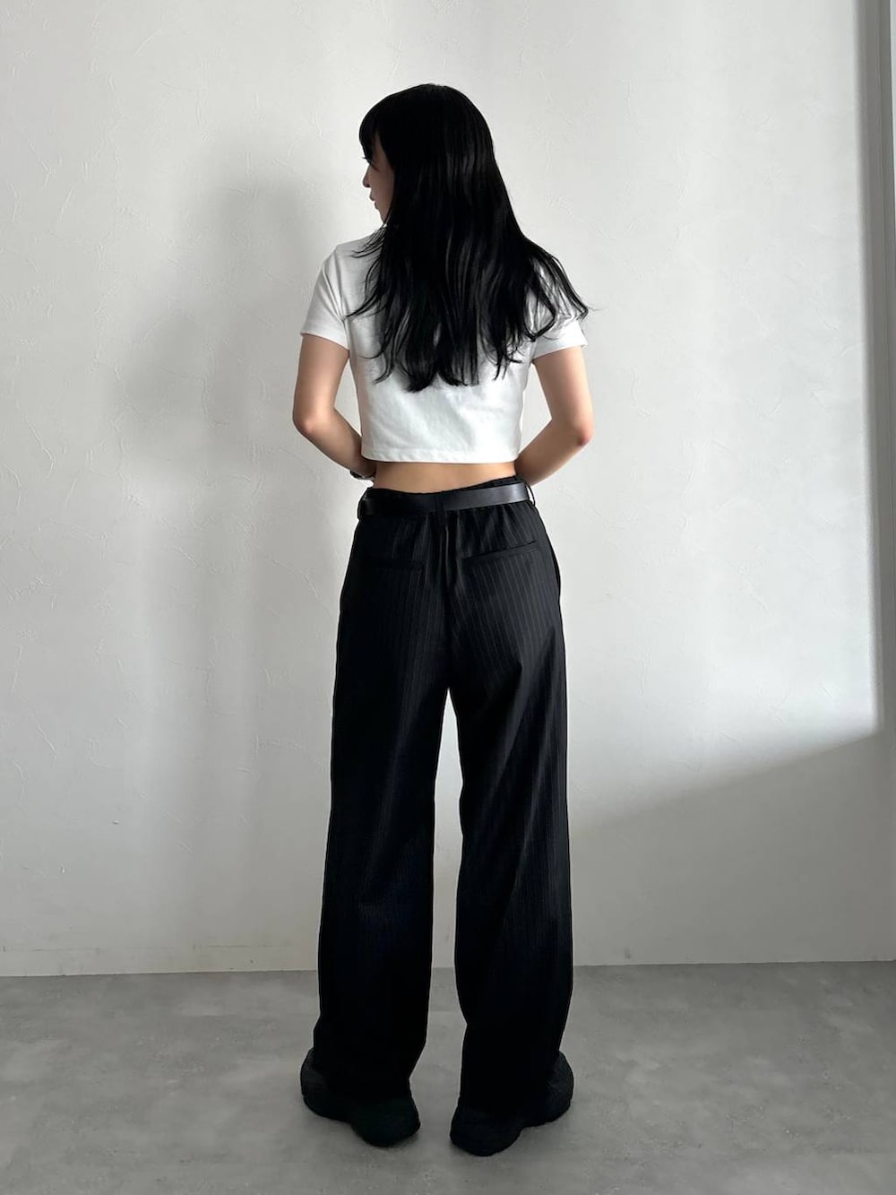 ホワイト系のTシャツ/カットソー、ブラック系のスラックス、ブラック系のベルトを着用したレディースの春コーディネートの4枚目の写真