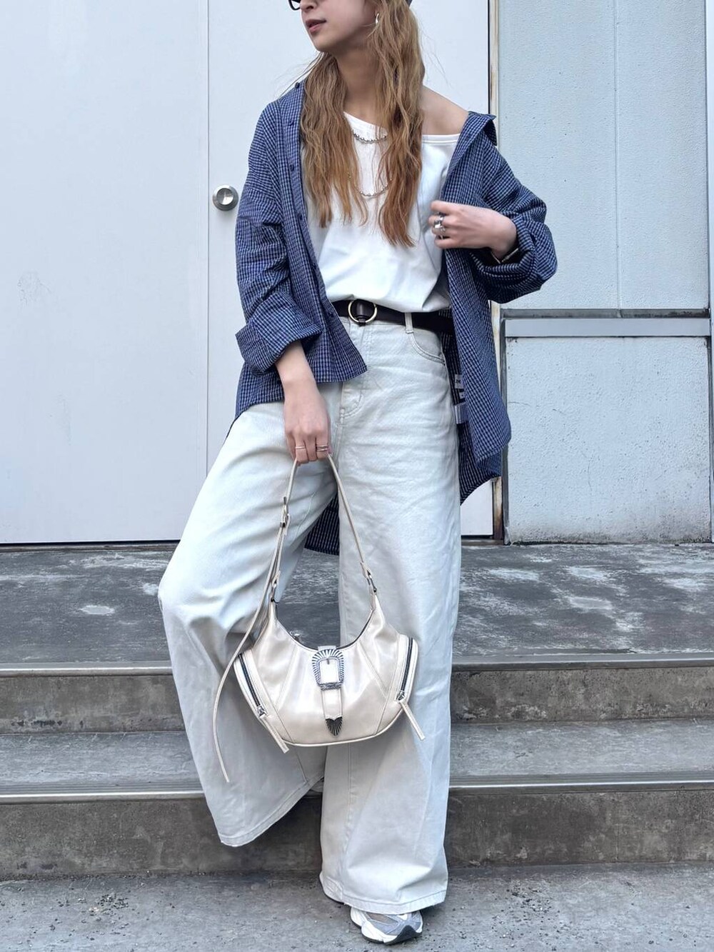 グレー系のデニムパンツ、ホワイト系のショルダーバッグ、ブルー系のシャツ/ブラウスを着用したレディースの春コーディネートの3枚目の写真
