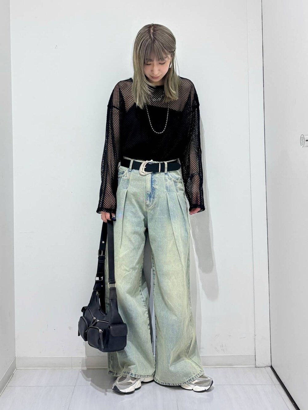 ブルー系のデニムパンツ、ブラック系のTシャツ/カットソー、ブラック系のショルダーバッグを着用したレディースの春コーディネートの5枚目の写真