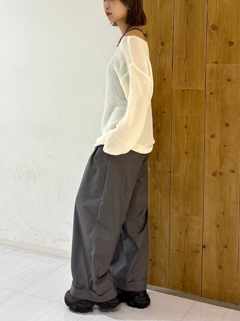 グレー系のスニーカー、ホワイト系のニット/セーター、グレー系のスラックスを着用したレディースの夏コーディネートの4枚目の写真