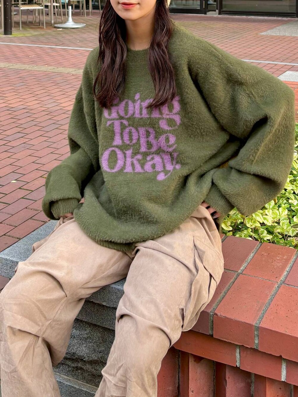 ベージュ系のカーゴパンツ、グリーン系のニット/セーター、ベージュ系のハットを着用したレディースの秋コーディネートの2枚目の写真