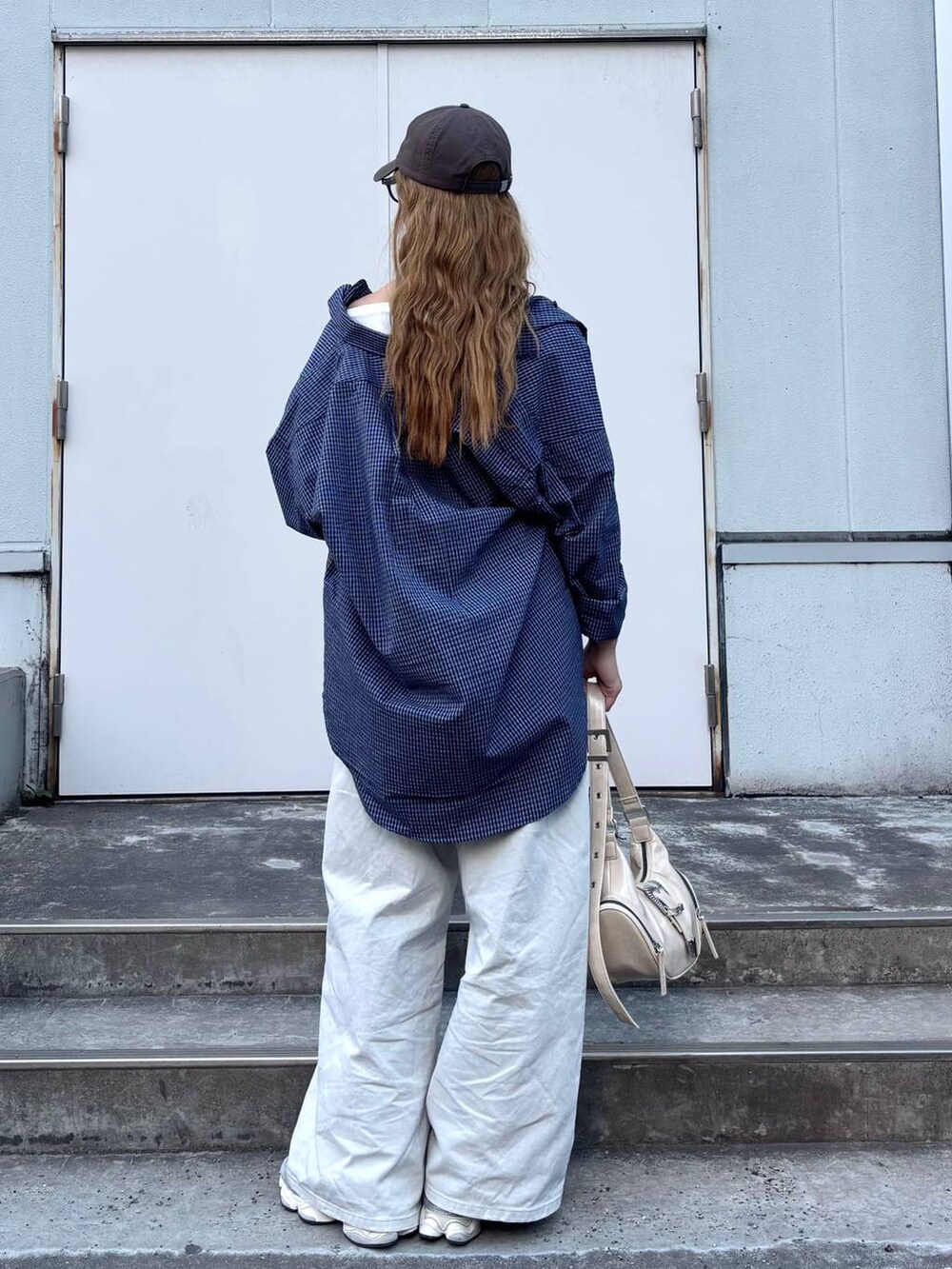 グレー系のデニムパンツ、ホワイト系のショルダーバッグ、ブルー系のシャツ/ブラウスを着用したレディースの春コーディネートの5枚目の写真