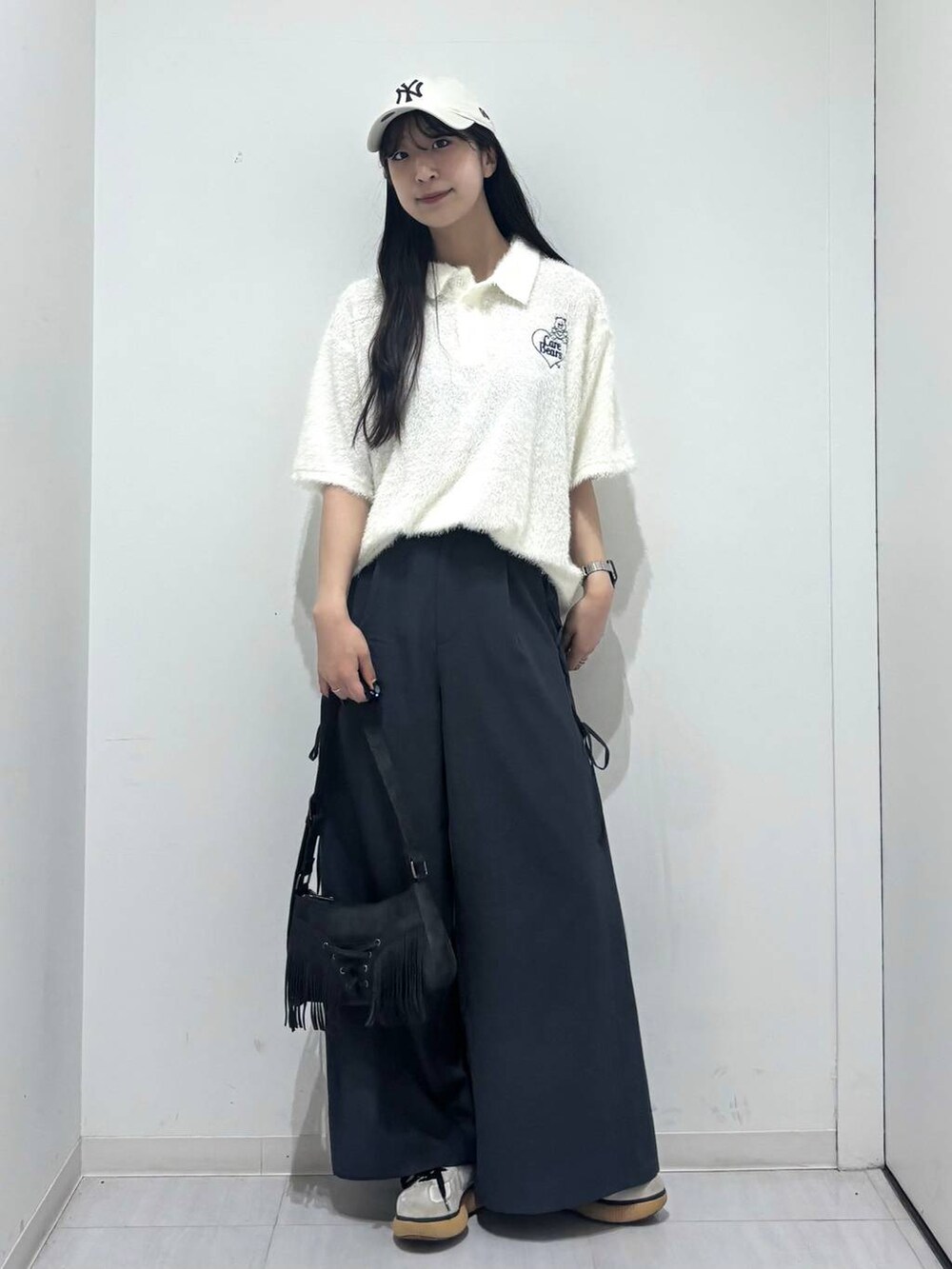 ブラック系のショルダーバッグ、グレー系のスラックス、ホワイト系のポロシャツを着用したレディースの春コーディネートの9枚目の写真