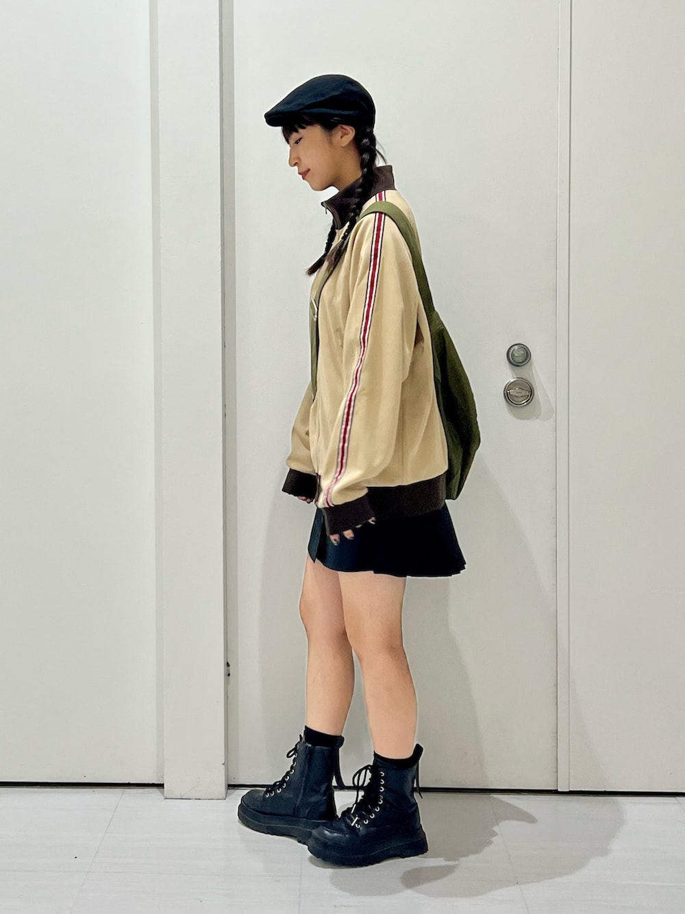 ベージュ系のセットアップ、グリーン系のショルダーバッグ、ブラック系のブーツを着用したレディースの秋コーディネートの3枚目の写真